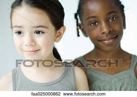 Two girls side by side, smiling, one looking at camera View Large Photo Image Stock Image - Two girls side by side, smiling, one looking at camera. Fotosearch