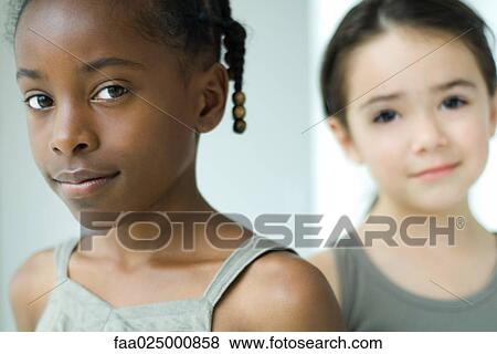 Two girls smiling at camera, focus on foreground View Large Photo Image Stock Photo - Two girls smiling at camera, focus on foreground. Fotosearch