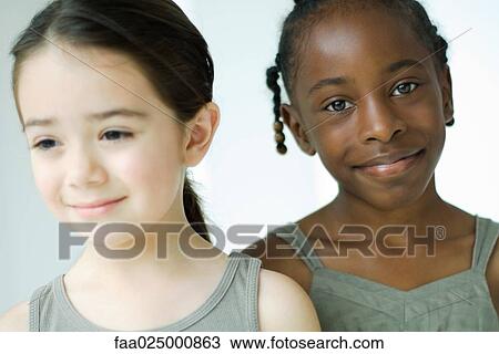 Two girls smiling, one looking at camera View Large Photo Image Stock Image - Two girls smiling, one looking at camera. Fotosearch
