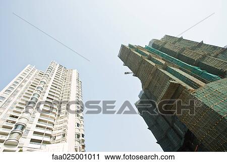 Two high rises, one surrounded by scaffolding, low angle view View Large Photo Image Stock Image - Two high rises, one surrounded by scaffolding, low angle view. Fotosearch