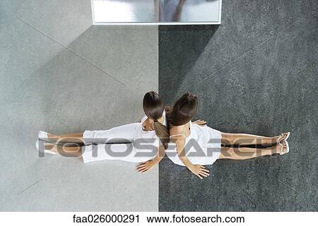 Two teenage girls sitting back to back on black and white divided floor, viewed from directly above View Large Photo Image Stock Image - Two teenage girls sitting back to back on black and white divided floor, viewed from directly above. Fotosearch