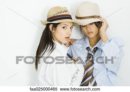 Two young females dressed in men's clothing and hats, one looking at camera View Large Photo Image Stock Photography - Two young females dressed in men's clothing and hats, one looking at camera. Fotosearch