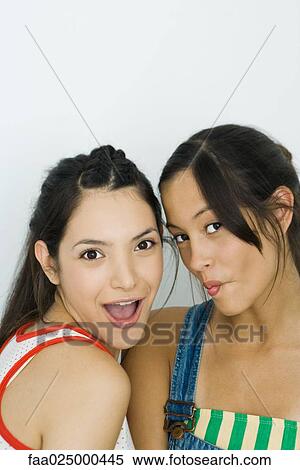 Two young friends looking at camera, one smiling, the other puckering lips View Large Photo Image Stock Photography - Two young friends looking at camera, one smiling, the other puckering lips. Fotosearch