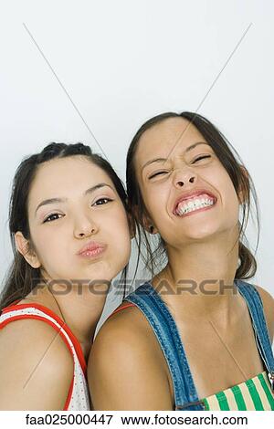 Two young friends making faces at camera, portrait View Large Photo Image Stock Photo - Two young friends making faces at camera, portrait. Fotosearch