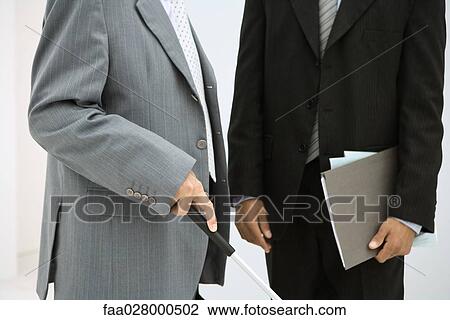 Stock Image - Visually impaired man with associate, cropped view of mid section. Fotosearch
