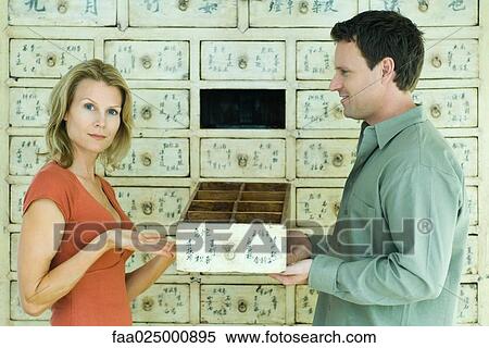 Woman and man holding drawer together, woman gesturing toward drawer and looking at camera View Large Photo Image Stock Photography - Woman and man holding drawer together, woman gesturing toward drawer and looking at camera. Fotosearch