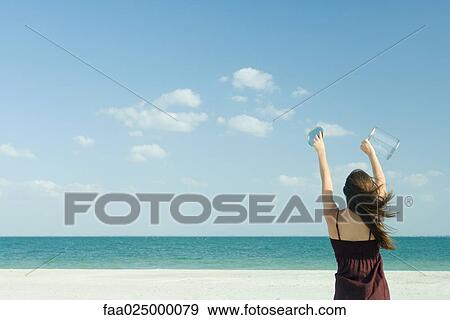 Stock Photo - Woman catching clouds in container. Fotosearch