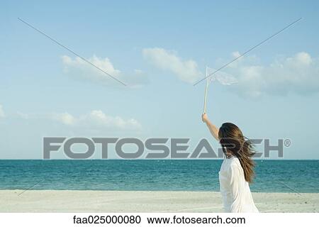 Woman catching clouds with butterfly net View Large Photo Image Stock Image - Woman catching clouds with butterfly net. Fotosearch