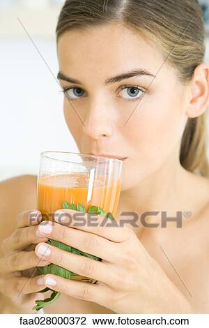 Woman drinking glass of vegetable juice, looking at camera View Large Photo Image Stock Image - Woman drinking glass of vegetable juice, looking at camera. Fotosearch