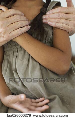 Woman embracing little girl, close-up, cropped view View Large Photo Image Stock Photo - Woman embracing little girl, close-up, cropped view. Fotosearch