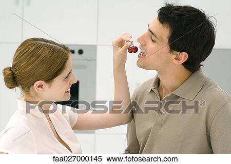 Woman feeding man cherries, side view View Large Photo Image Stock Photography - Woman feeding man cherries, side view. Fotosearch