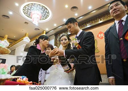 Woman helping bride and groom open champagne bottle, low angle view View Large Photo Image Stock Photograph - Woman helping bride and groom open champagne bottle, low angle view. Fotosearch