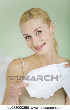 Woman holding baby diaper, smiling at camera View Large Photo Image Stock Image - Woman holding baby diaper, smiling at camera. Fotosearch