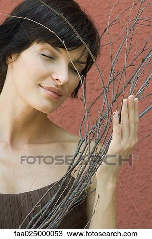 Woman holding dry branches, eyes closed View Large Photo Image Stock Image - Woman holding dry branches, eyes closed. Fotosearch