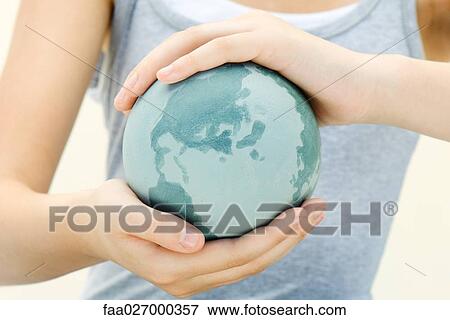 Woman holding globe in cupped hands, close-up, cropped view View Large Photo Image Stock Photo - Woman holding globe in cupped hands, close-up, cropped view. Fotosearch