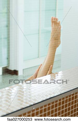 Woman holding up bare leg, cropped view View Large Photo Image Stock Image - Woman holding up bare leg, cropped view. Fotosearch