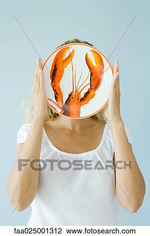 Woman holding up lobster plate in front of face View Large Photo Image Stock Image - Woman holding up lobster plate in front of face. Fotosearch