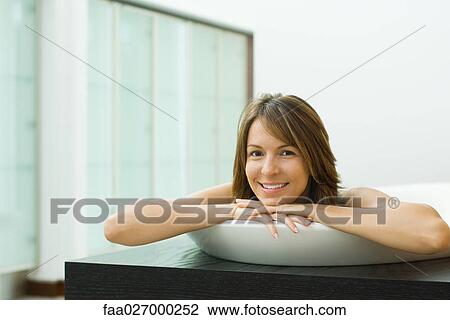 Woman in bathtub, head resting on arms, smiling at camera View Large Photo Image Stock Image - Woman in bathtub, head resting on arms, smiling at camera. Fotosearch