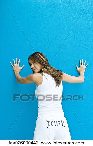 Woman in pants with the word "truth" on backside, standing with hands against wall, looking over shoulder at camera View Large Photo Image Stock Image - Woman in pants with the word "truth" on backside, standing with hands against wall, looking over shoulder at camera. Fotosearch
