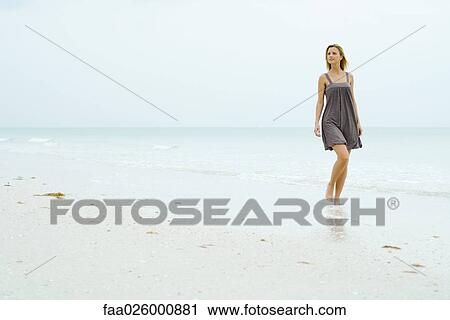 Woman in sundress walking at the beach, looking away View Large Photo Image Stock Image - Woman in sundress walking at the beach, looking away. Fotosearch