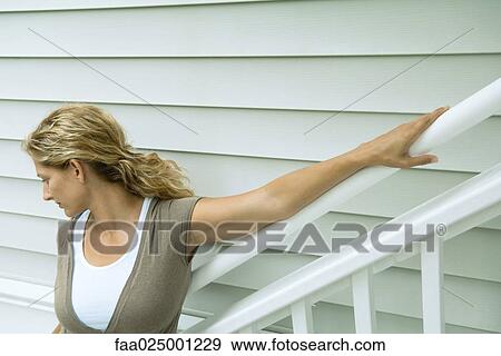Woman leaning against railing, looking away View Large Photo Image Stock Photo - Woman leaning against railing, looking away. Fotosearch