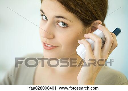 Woman listening to baby monitor, smiling at camera View Large Photo Image Stock Image - Woman listening to baby monitor, smiling at camera. Fotosearch