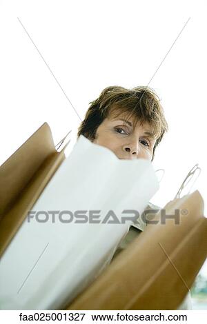 Woman looking over paper bags View Large Photo Image Stock Photo - Woman looking over paper bags. Fotosearch