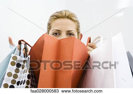 Woman looking over several shopping bags View Large Photo Image Stock Image - Woman looking over several shopping bags. Fotosearch