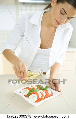 Woman pouring olive oil on antipasto View Large Photo Image Stock Photo - Woman pouring olive oil on antipasto. Fotosearch