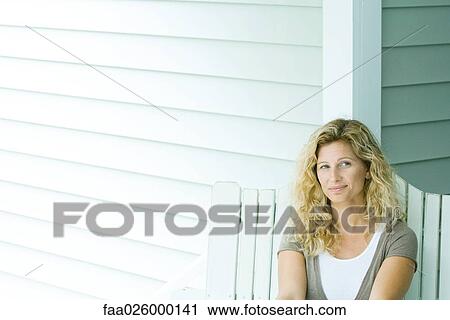 Woman sitting on bench, smiling, looking away View Large Photo Image Stock Image - Woman sitting on bench, smiling, looking away. Fotosearch