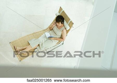 Woman sitting on lounge chair writing in diary, high angle view View Large Photo Image Stock Photography - Woman sitting on lounge chair writing in diary, high angle view. Fotosearch