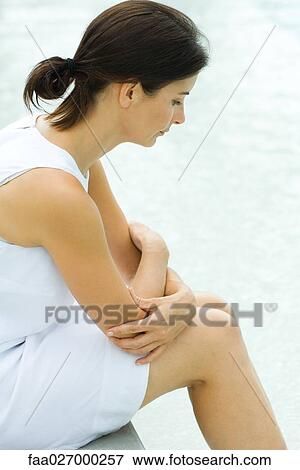 Woman sitting with arms folded, head down, side view View Large Photo Image Stock Photo - Woman sitting with arms folded, head down, side view. Fotosearch
