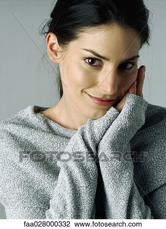 Woman smiling at camera, hands clasped next to cheek, portrait View Large Photo Image Stock Image - Woman smiling at camera, hands clasped next to cheek, portrait. Fotosearch