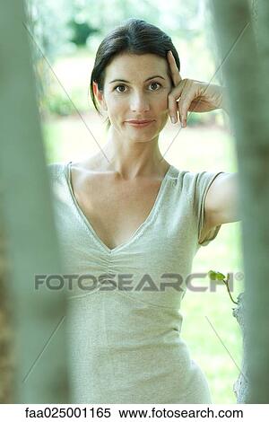 Woman smiling at camera through trees View Large Photo Image Stock Photography - Woman smiling at camera through trees. Fotosearch