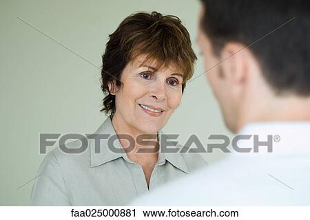 Woman smiling at man in foreground, over the shoulder view View Large Photo Image Stock Image - Woman smiling at man in foreground, over the shoulder view. Fotosearch