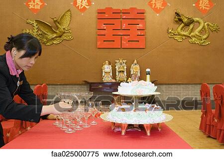 Woman stacking champagne glasses on table next to wedding cake View Large Photo Image Stock Photography - Woman stacking champagne glasses on table next to wedding cake. Fotosearch