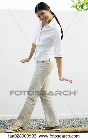 Woman standing on bamboo poles, smiling at camera, full length View Large Photo Image Stock Image - Woman standing on bamboo poles, smiling at camera, full length. Fotosearch