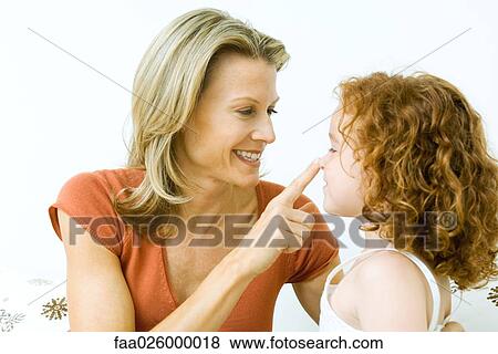 Woman touching daughter's nose, both smiling View Large Photo Image Stock Photo - Woman touching daughter's nose, both smiling. Fotosearch
