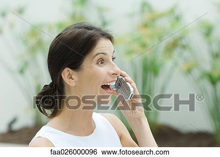 Woman using cell phone, wide-eyes, open mouth View Large Photo Image Stock Photograph - Woman using cell phone, wide-eyes, open mouth. Fotosearch