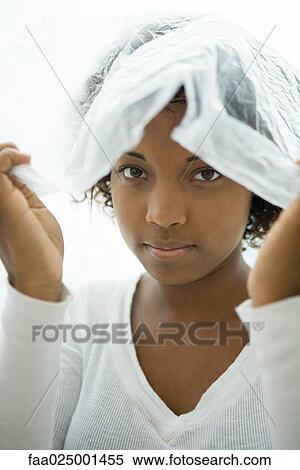 Stock Photography - Woman with plastic bag on her head, looking out at camera. Fotosearch