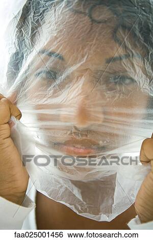Woman with plastic bag over face, looking at camera View Large Photo Image Stock Photograph - Woman with plastic bag over face, looking at camera. Fotosearch