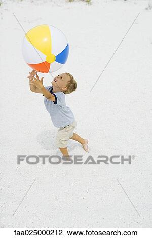 Young boy catching beach ball, arms raised, side view View Large Photo Image Stock Image - Young boy catching beach ball, arms raised, side view. Fotosearch