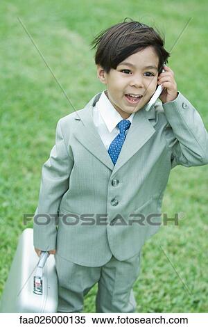 Young boy dressed in suit, using cell phone, carrying briefcase View Large Photo Image Stock Photography - Young boy dressed in suit, using cell phone, carrying briefcase. Fotosearch