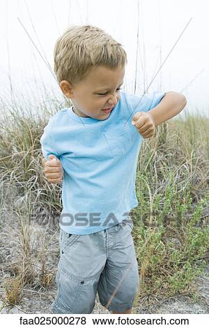 Young boy holding up elbow, wrinkling nose View Large Photo Image Stock Photo - Young boy holding up elbow, wrinkling nose. Fotosearch