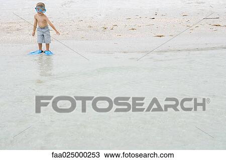 Young boy in swimming mask and flippers, standing ankle deep in water View Large Photo Image Stock Image - Young boy in swimming mask and flippers, standing ankle deep in water. Fotosearch