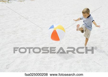 Young boy kicking beach ball at the beach, arms out View Large Photo Image Stock Photo - Young boy kicking beach ball at the beach, arms out. Fotosearch