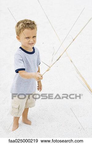 Young boy pretending to sword fight with stick View Large Photo Image Stock Photo - Young boy pretending to sword fight with stick. Fotosearch