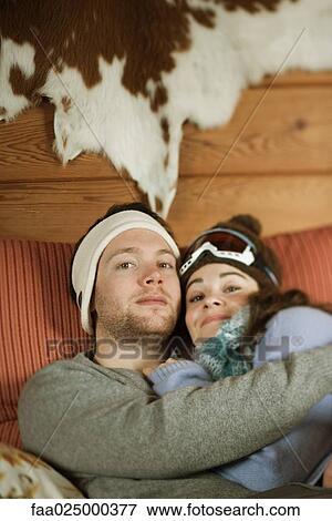 Young couple reclining on couch, smiling at camera View Large Photo Image Stock Photo - Young couple reclining on couch, smiling at camera. Fotosearch