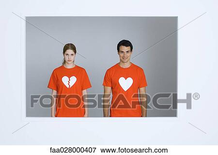Young couple wearing tee-shirts with heart symbols, woman's heart broken View Large Photo Image Stock Photo - Young couple wearing tee-shirts with heart symbols, woman's heart broken. Fotosearch
