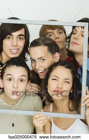 Young friends looking at camera through picture frame, group portrait View Large Photo Image Stock Photography - Young friends looking at camera through picture frame, group portrait. Fotosearch